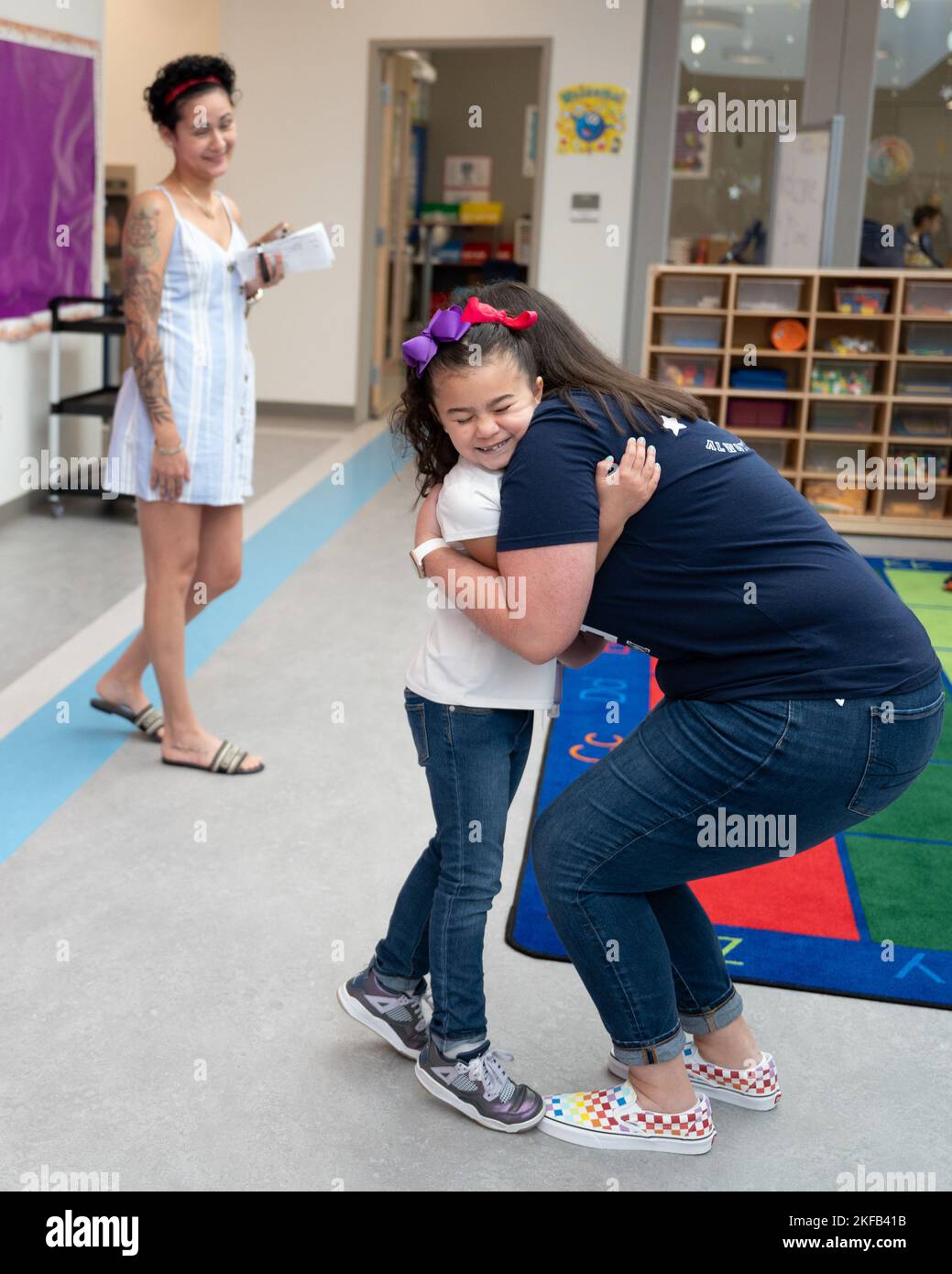 Gineilly Jireh Hernandez salue Chelsea Billings, assistante de la maternelle à l'école primaire Hanscom, lors d'une rencontre avec des enseignants des écoles primaires et intermédiaires de la base aérienne Hanscom, Mass., 1 septembre, tandis que la mère de Gineilly, Gineish Otero, regarde. Le campus de l'AFB Hanscom comprend deux écoles, une école primaire pour les élèves de la maternelle à la troisième année et une école secondaire pour les élèves de la quatrième à la huitième année. Les deux écoles sont entièrement fournies et financées par l'activité d'éducation du ministère de la Défense et sont exploitées dans le cadre de l'école publique Lincoln Banque D'Images