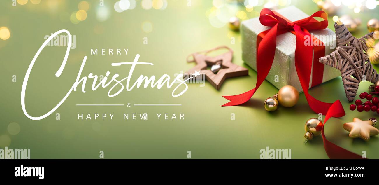 Carte de vœux de Noël - Joyeux Noël et bonne année - boîte cadeau et ornements sur fond vert clair avec lumières magiques - bannière, en-tête Banque D'Images