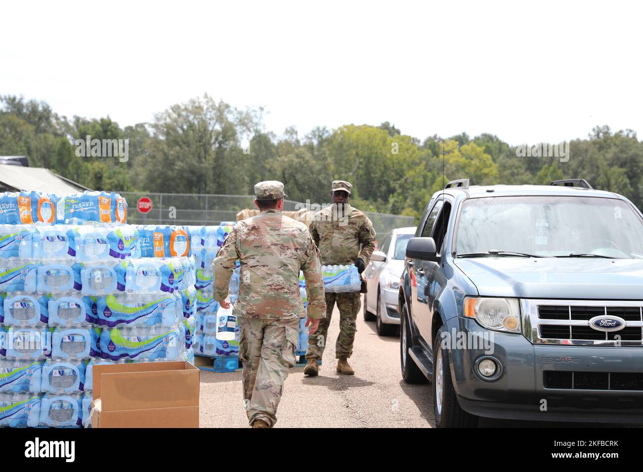 Les soldats du 1st Bataillon, 185th Aviation Regiment, 66th troupe Command, Mississippi Army National Guard, distribuent de l'eau à l'école moyenne Thomas Cardozo à Jackson, Mississippi, le 2 septembre 2022. Près de 600 gardes nationaux du Mississippi ont été établis sur sept sites à travers Jackson pour permettre aux gens de recueillir de l'eau en bouteille, de l'assainisseur pour les mains et de l'eau non potable dans des camions de buffles d'eau. Banque D'Images