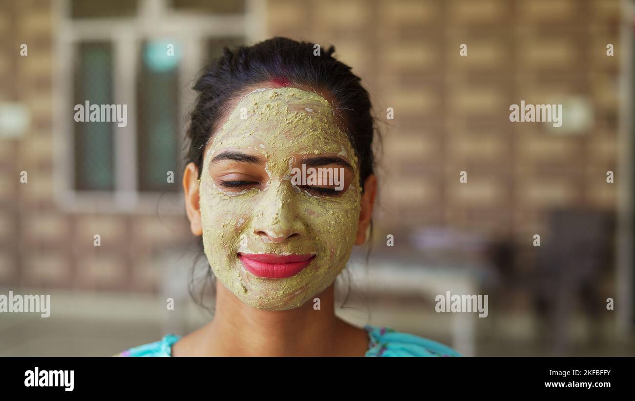 Belle jeune femme utilisant un masque facial maison sur le visage et se détendre à la maison. Femmes asiatiques avec Multani Mitti et Rose Water face Pack. Portrait de sp Banque D'Images