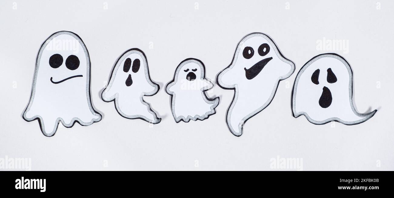 Fantômes charmants et amusants avec visages sur fond blanc, vue de dessus Banque D'Images