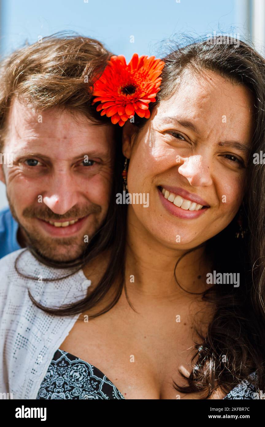 portrait vertical d'un couple hétérosexuel d'adulte latin souriant et regardant la caméra, homme argentin avec barbe et caucasien à côté de son wif brésilien Banque D'Images