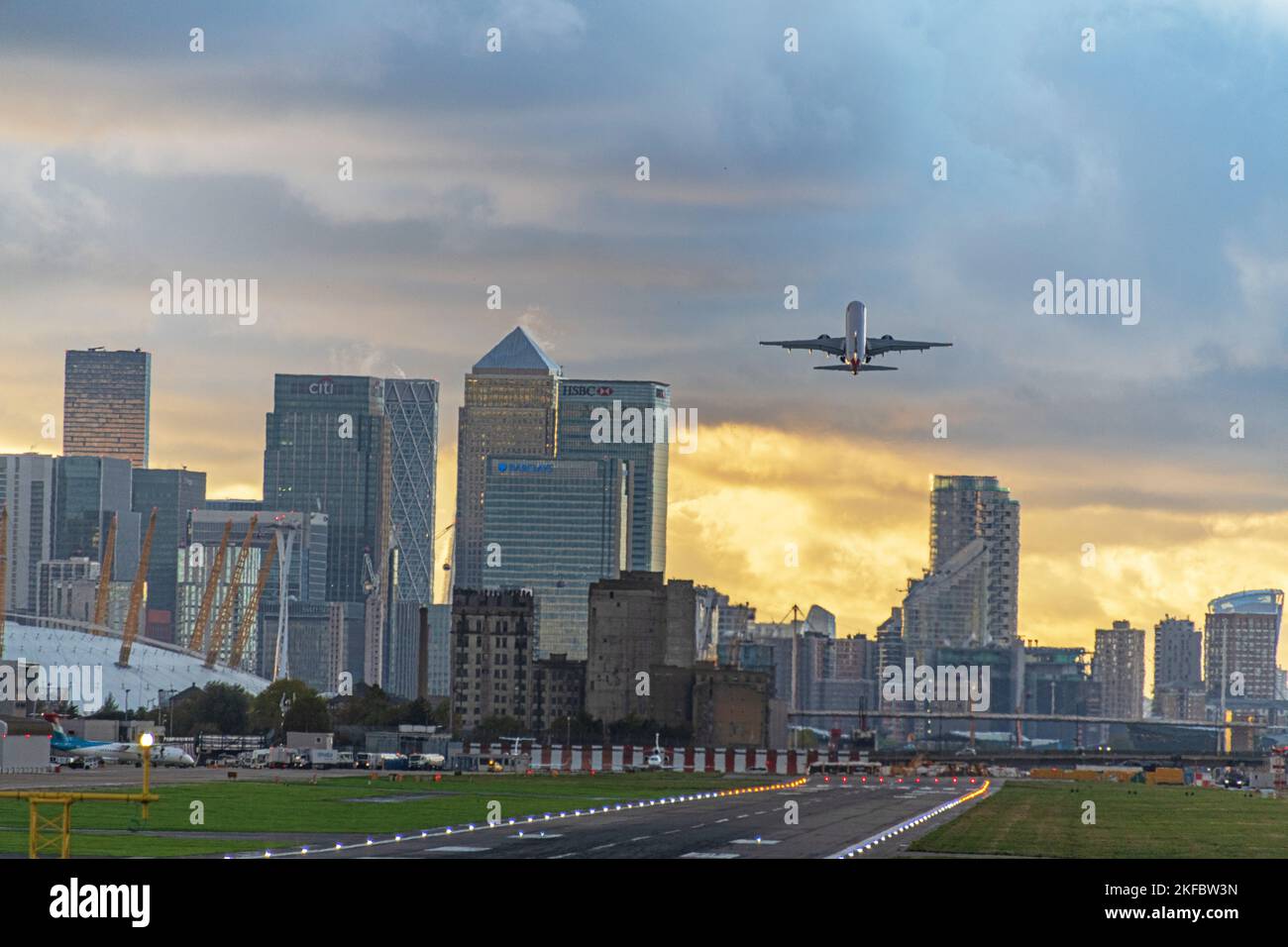 Un Embraer ERJ-190 de British Airways déferle dans les nuages sombres de l'aéroport de London City. Banque D'Images