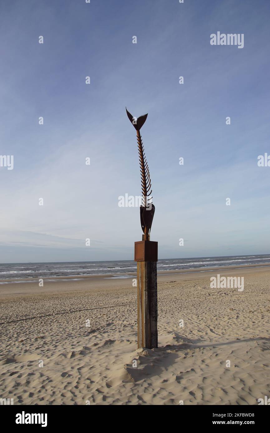 Sculpture d'acier corten d'un poisson sur un poteau en bois sur la plage près de la mer du Nord. Automne, novembre. Bergen aan Zee, pays-Bas Banque D'Images