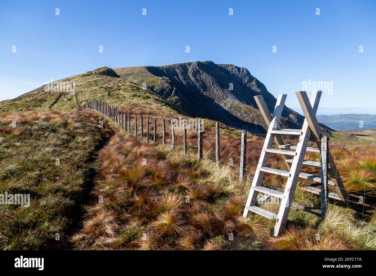 En regardant vers la montagne Mynydd Moel avec un style en bois pour traverser la clôture. Banque D'Images