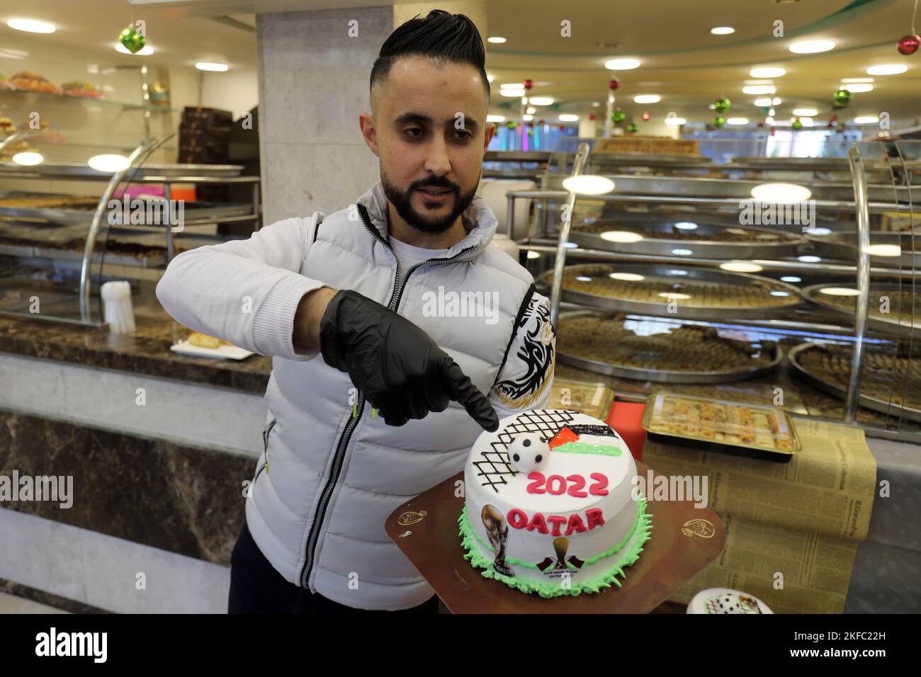 Un boulanger palestinien présente un gâteau décoré d'articles liés à la coupe du monde du Qatar 2022, dans son magasin de la bande de Gaza, le 17 novembre 2022. Banque D'Images