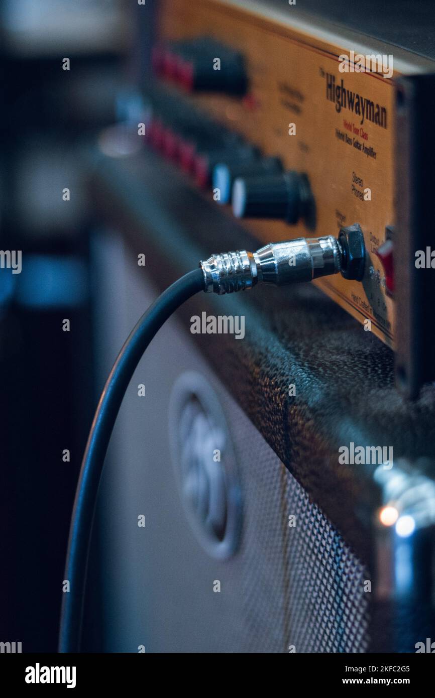 Un gros plan vertical de matériel musical Highwayman pour guitare basse en lumière bleue Banque D'Images