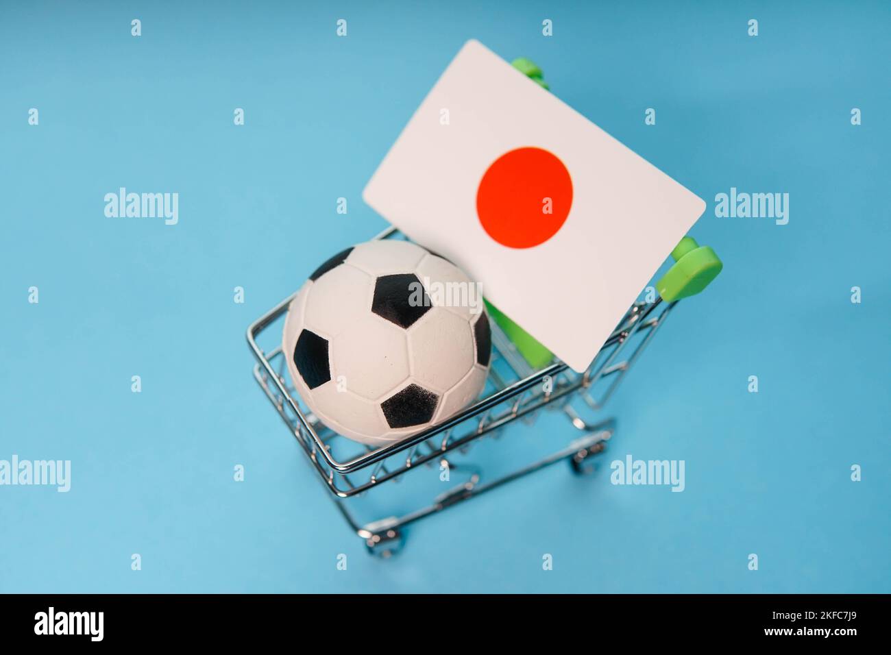 Ballon de football avec drapeau japonais dans le panier sur fond bleu. Les gains de la coupe de football. Banque D'Images