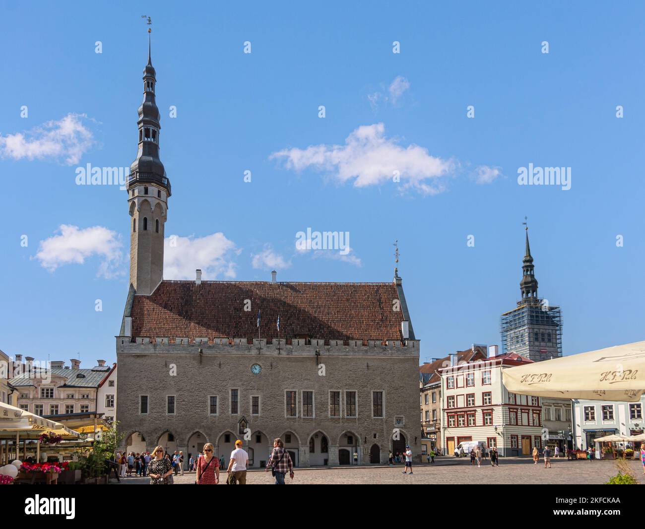 Estonie, Tallinn - 21 juillet 2022: Hôtel de ville, raekoda, domine la place nommée d'après elle sous le paysage bleu. Façades d'affaires sur les côtés et sur le piédestr Banque D'Images