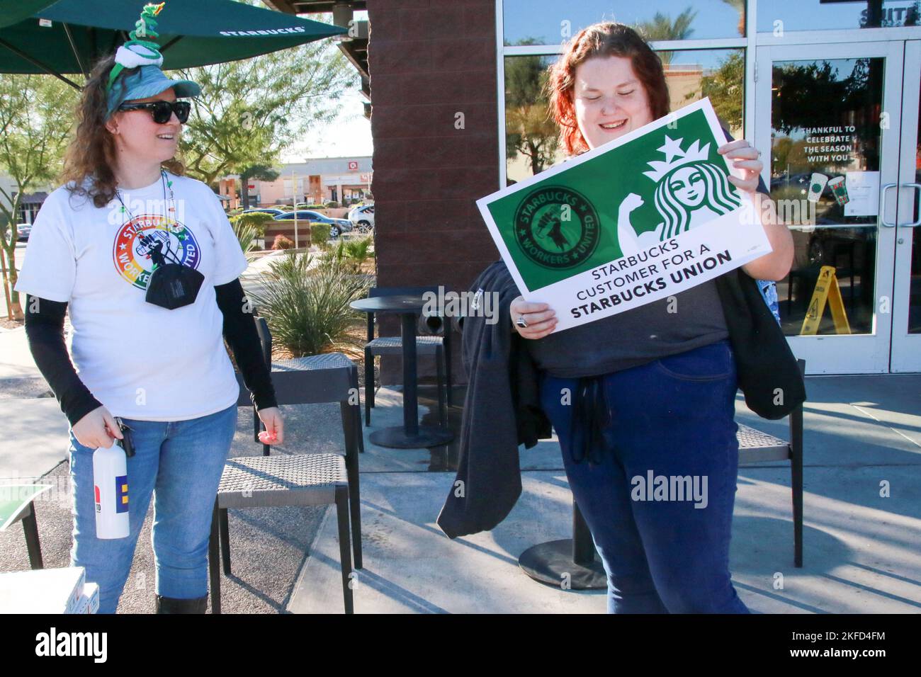 Un client se voit remettre un panneau indiquant le soutien syndical des travailleurs participant à la grève nationale d'une journée dans le premier magasin de l'Arizona pour se syndiquer à Mesa, Arizona, États-Unis, sur 17 novembre 2022. Plus de 2 000 employés de 112 sites Starbucks sont en grève dans ce qu'ils appellent la rébellion de la coupe Rouge pour protester contre les représailles prises contre les partisans syndicaux dans tout le pays. Les grévistes distribuent des gobelets « Red Starbucks Workers United » aux clients dans le cadre de la plus grande journée d'action coordonnée organisée par les magasins Starbucks de l'histoire de campaignÕs. (Photo : Alexandra Buxbaum/Sipa USA) Banque D'Images