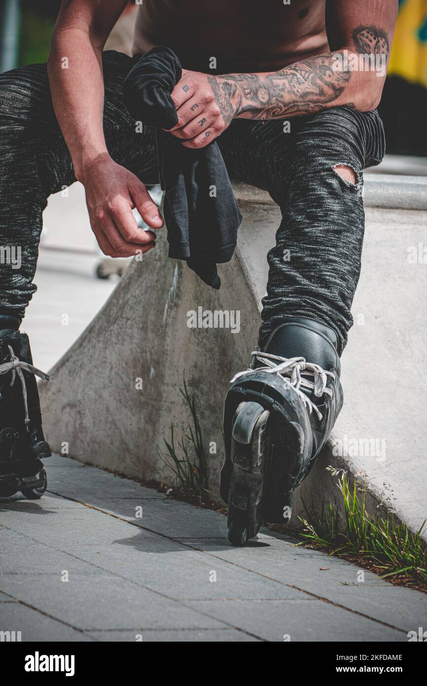 Un cliché vertical d'un patineur à roulettes assis sur un rocher Banque D'Images