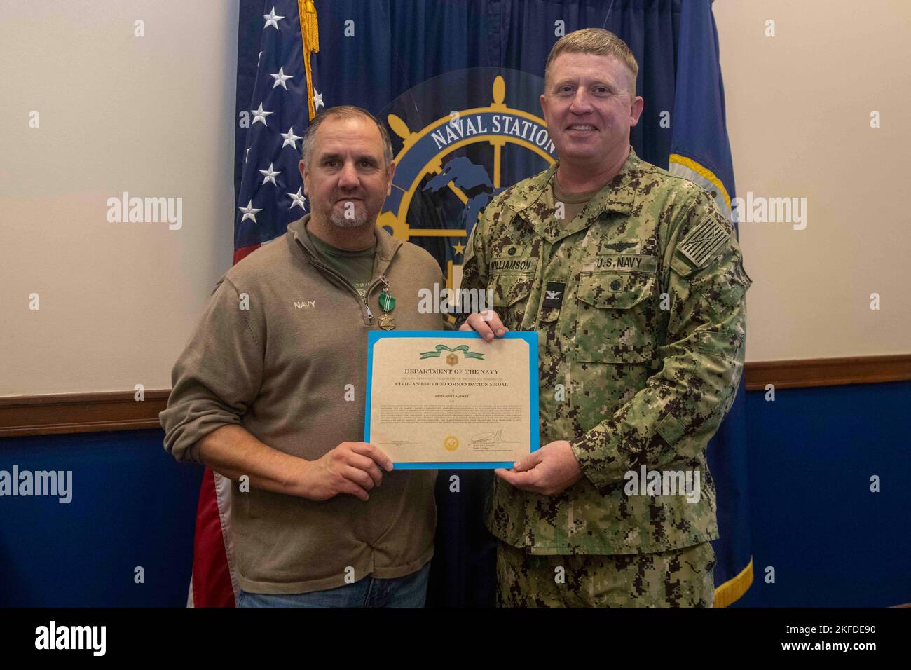 GRANDS LACS, il. (Sept 9, 2022) le capitaine Jason Williamson, commandant de la Station navale des Grands Lacs, remet à Kevin Barnett, officier d'administration, une médaille de mention élogieuse pour le service civil. Inauguré en 1911, le NSGL est la plus grande installation d’entraînement de la Marine et le seul camp d’entraînement de la Marine. Située sur plus de 1600 hectares surplombant le lac Michigan, l'installation comprend 1 153 bâtiments dont 39 sur le registre national des lieux historiques. Le NSGL soutient plus de 50 commandements et éléments de locataires ainsi que plus de 20 000 marins, marins, soldats et civils du DoD qui vivent et travaillent sur les INS Banque D'Images