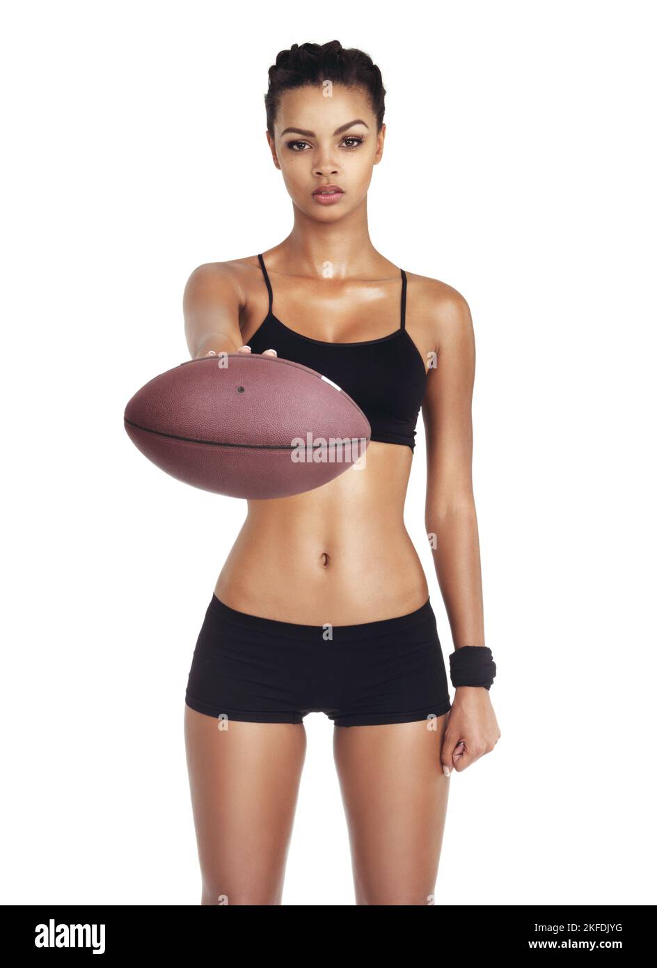 Tu as du jeu. Portrait studio d'une jeune femme en tenue sportive tenant un ballon de football isolé sur blanc. Banque D'Images