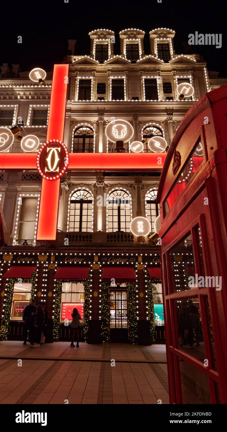 Exposition illuminée de Noël avec effet ruban aux bijoutiers Cartier avec boîte téléphonique rouge, New Bond Street, Londres. Banque D'Images