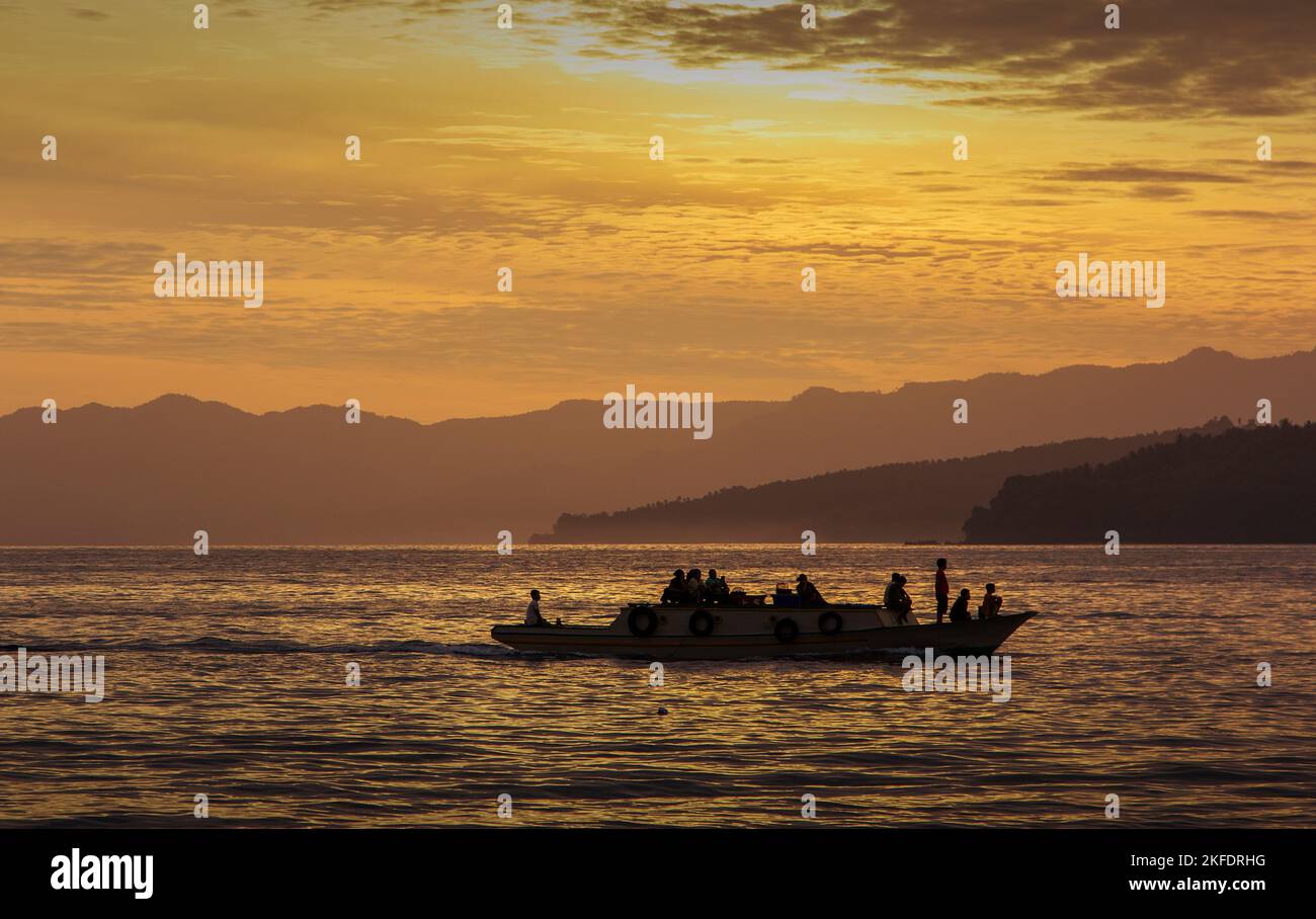 Activités matinales des communautés côtières avec des bateaux en bois et le lever du soleil comme toile de fond dans la ville de Ternate, au nord de Maluku, en Indonésie Banque D'Images