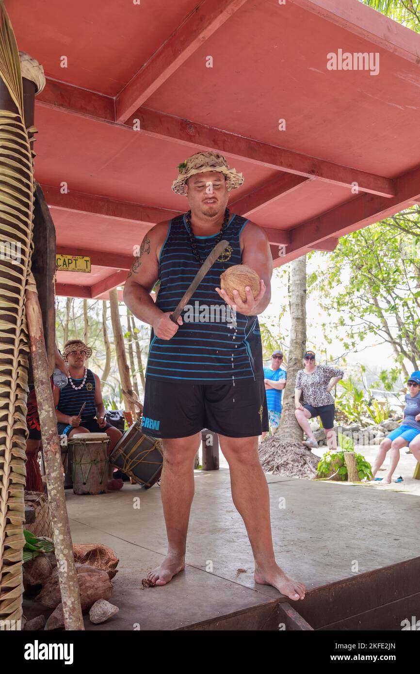 Un homme polynésien montre comment ouvrir une noix de coco avec une machette lors d'un spectacle culturel sur Rarotonga, îles Cook Banque D'Images