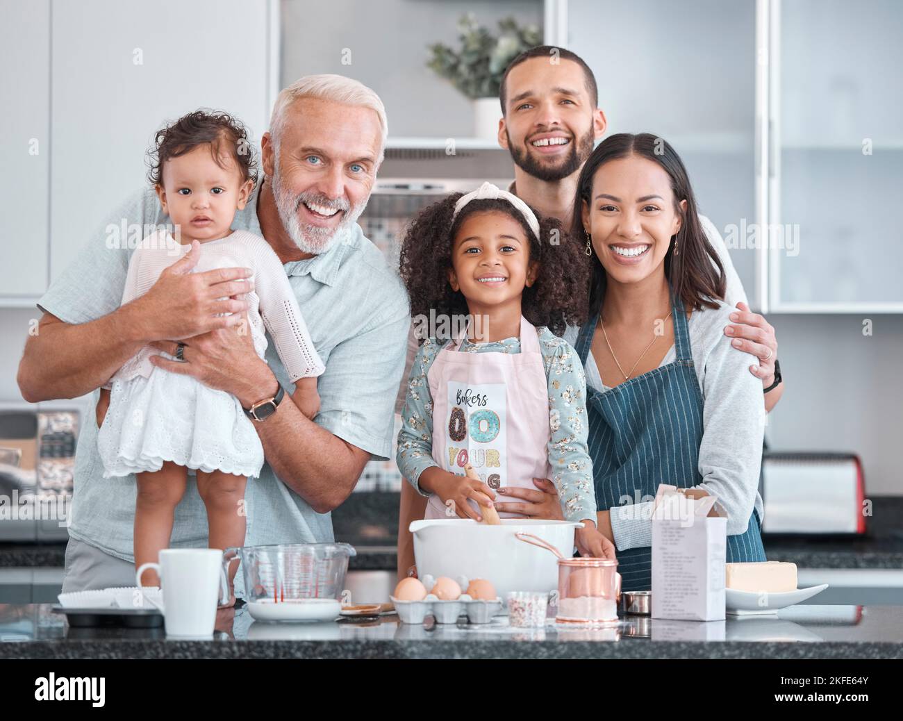 Grande famille, portrait et enfants apprenant la pâtisserie de parents et grand-père dans la cuisine de leur maison. Nourriture, heureux et enfants, homme âgé et Banque D'Images