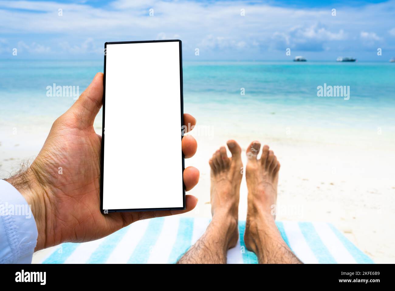 Téléphone mobile ou smartphone avec écran vert sur la plage Banque D'Images