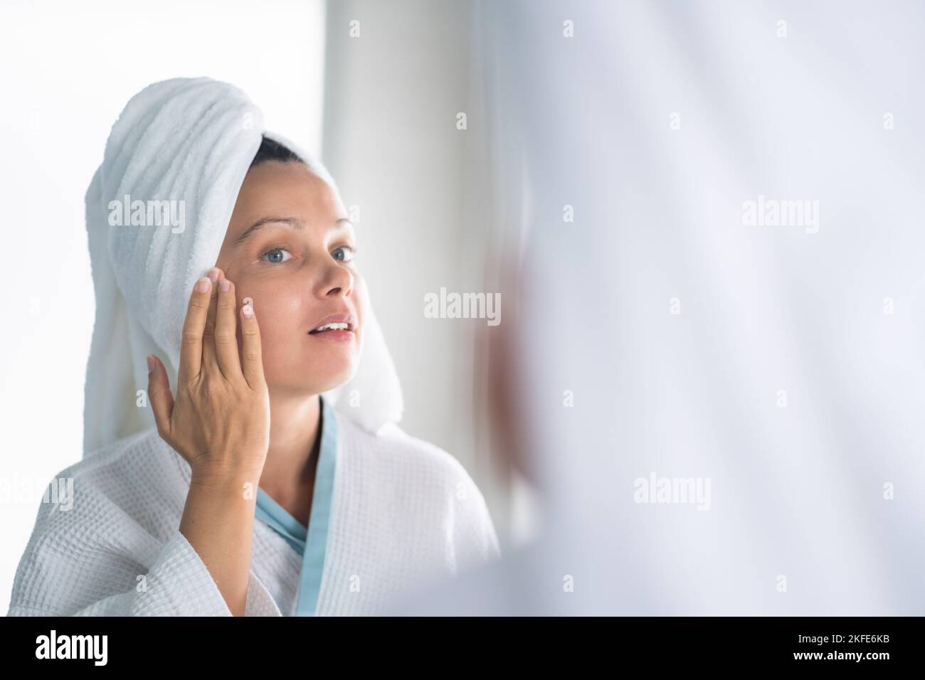 Femme appuyant le bouton sur son visage. Problème de peau d'acné Banque D'Images