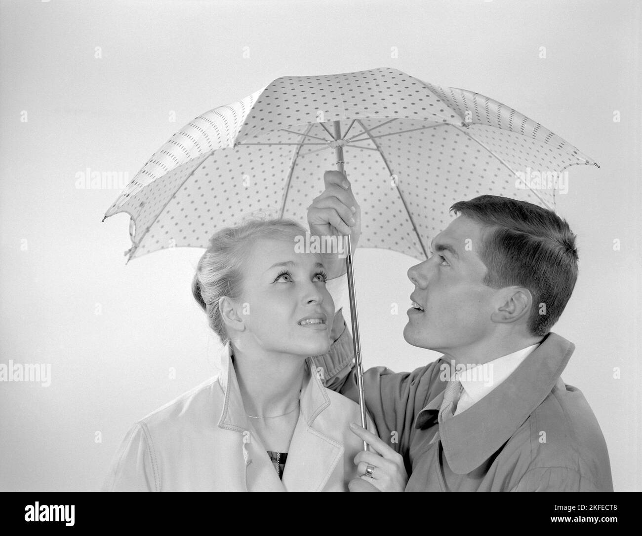 1960s couple. Un couple souriant se tient sous un parapluie. Suède 1960 Conard réf. 4254 Banque D'Images