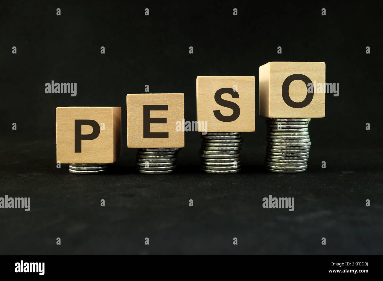 Devise du peso, croissance économique et financière et concept de reprise. Augmentation de la pile de pièces sur fond noir foncé avec le mot peso. Banque D'Images