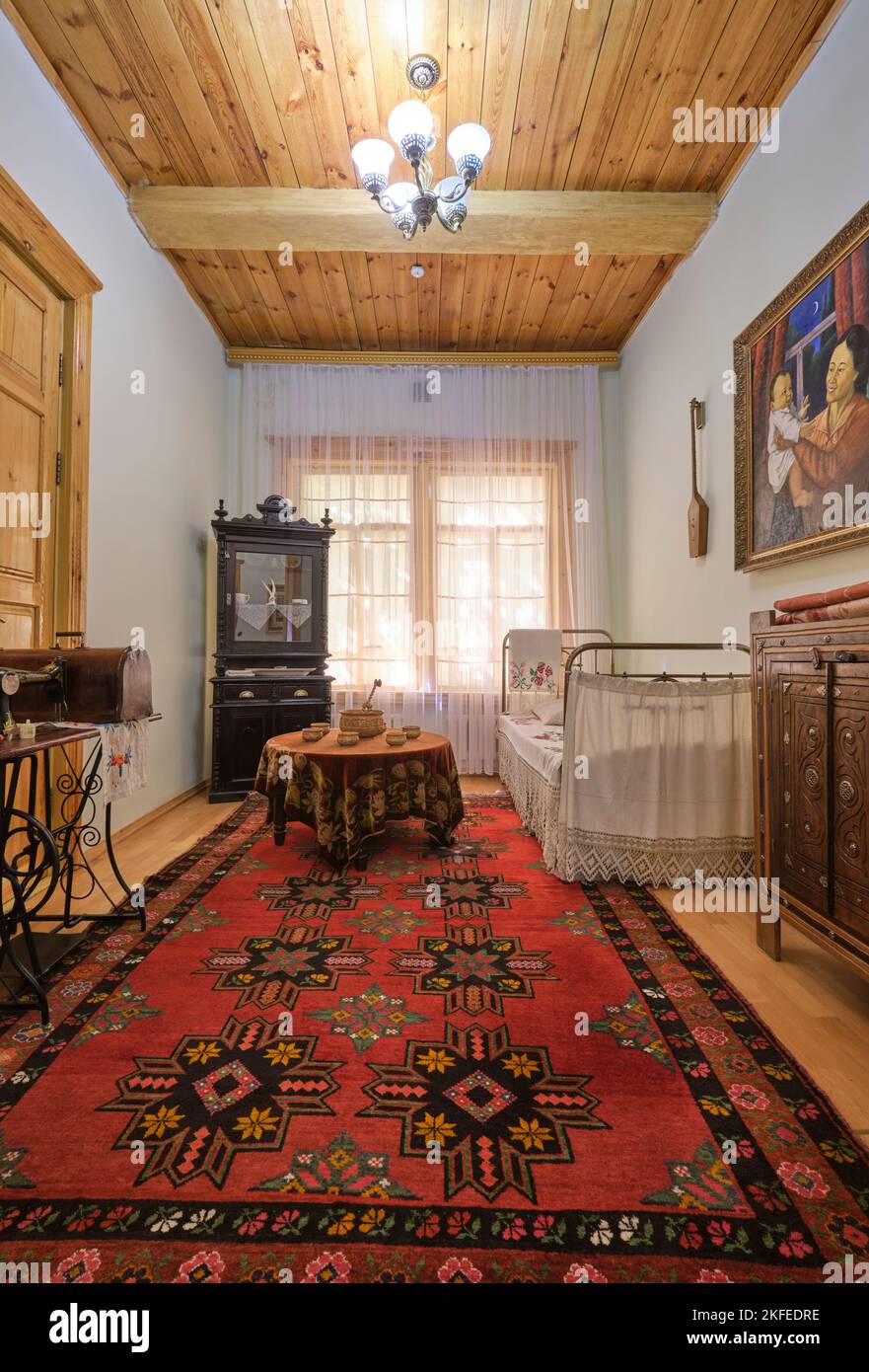Vue sur la chambre de l'écrivain avec lit en laiton blanc, tableaux, tapis, commode. À la maison du Musée Seifullin à Astana, Nur Sultan, Kazakhstan. Banque D'Images