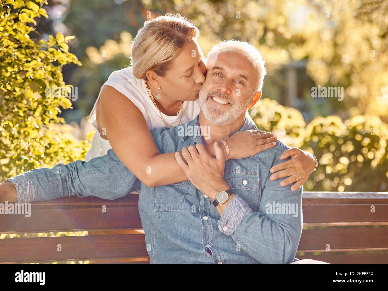 Amour, détente et heureux avec un vieux couple au banc du parc pour la retraite, le soutien et l'affectueux. Collage, baiser et embrasser avec le portrait de l'homme et de la femme Banque D'Images