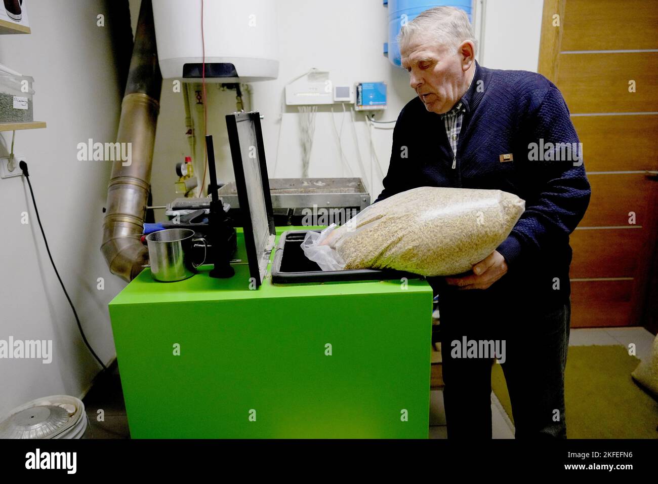 L'agriculteur lituanien Petras Vaitelis remplit son four de grains d'avoine pour chauffer sa maison à Azuolaiciai, Lituanie 14 novembre 2022. REUTERS/Ints Kalnins Banque D'Images