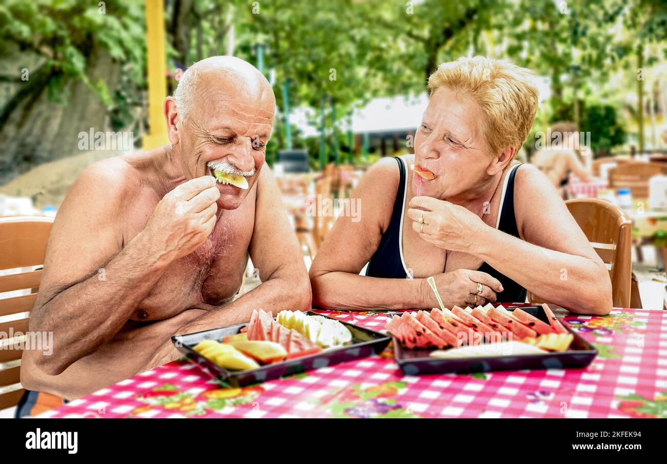 Couple senior ayant plaisir à manger des fruits de saison dans le bar restaurant thaïlandais en plein air - homme et femme mature sur des vacances actives de personnes âgées - heureuse retraite co Banque D'Images