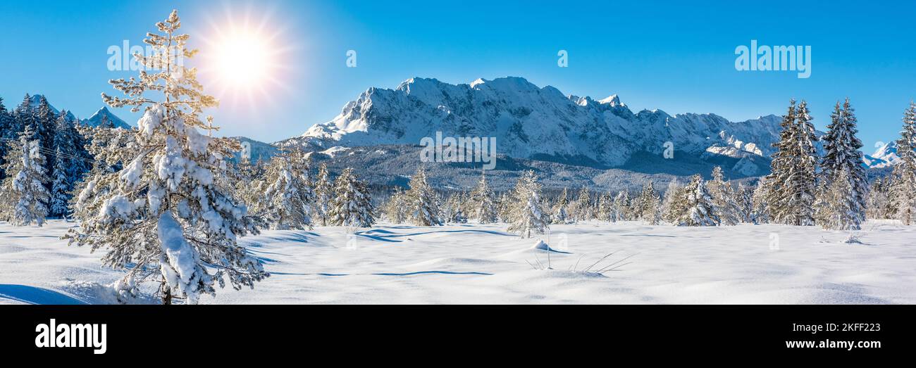 paysage en hiver avec chaîne de montagnes et soleil sur ciel bleu Banque D'Images