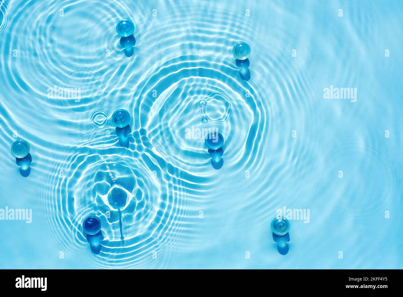 Fond bleu eau abstrait avec des ondulations, des cercles, avec des granules et le collagène concept pour le fond cosmétique et SPA pour les soins de la peau Banque D'Images