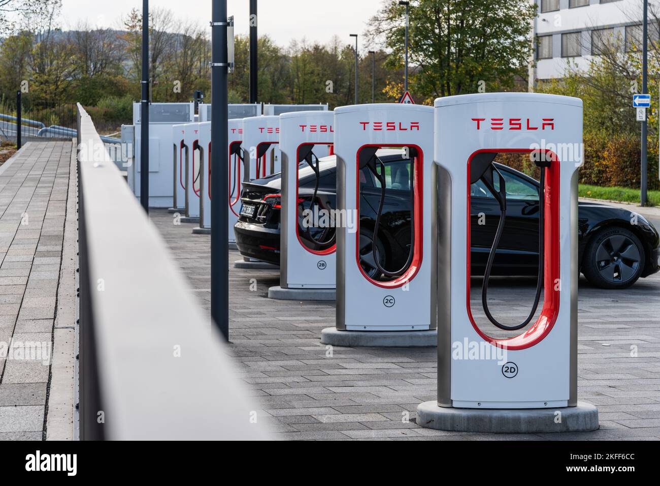 Une rangée de superchargeurs Tesla avec une voiture Tesla noire en charge à Wetzlar, en Allemagne Banque D'Images