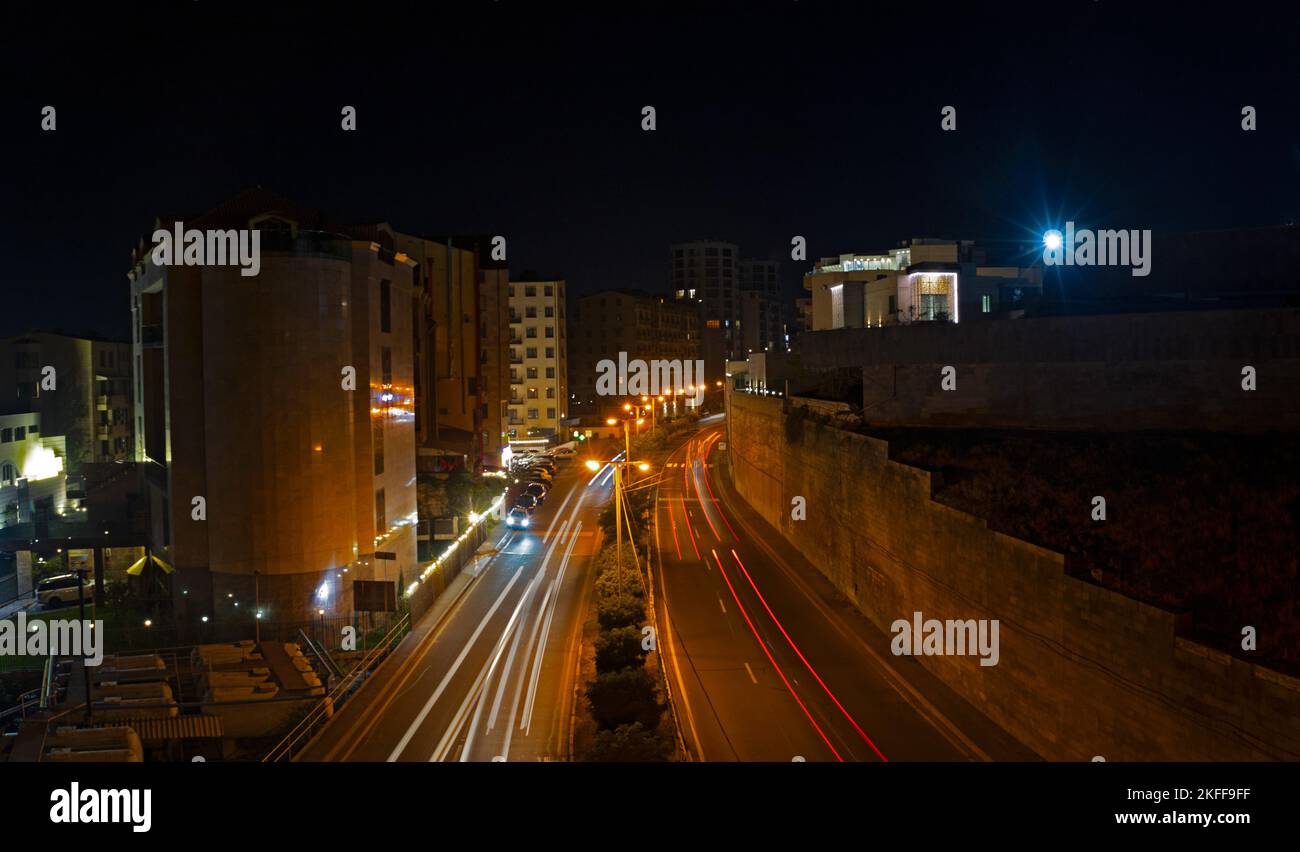 Des pistes lumineuses de voitures qui passent sur l'autoroute, prises avec une longue exposition. Lumière de vitesse de mouvement près de Cascade à Erevan. Banque D'Images