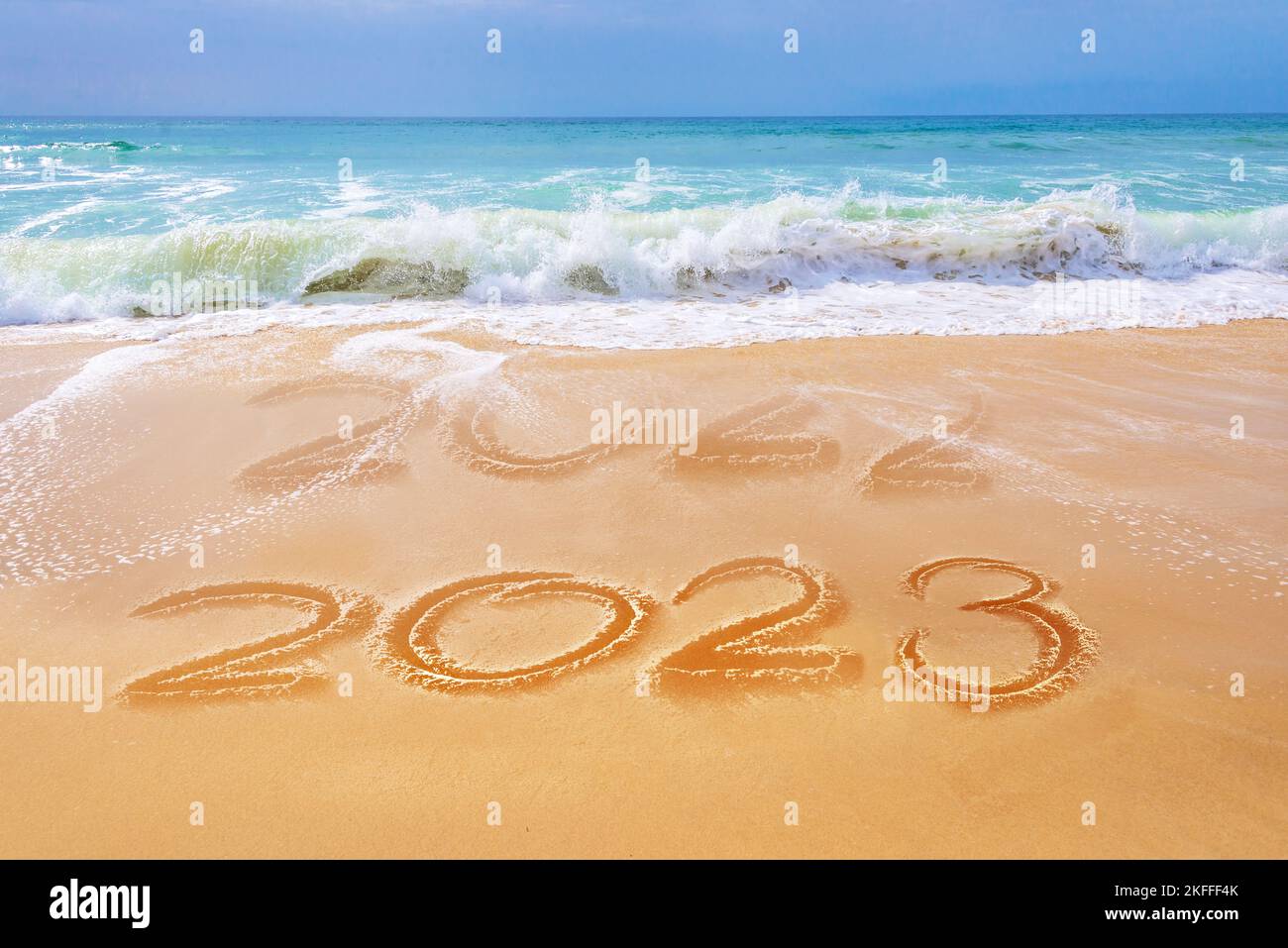 2023 écrit sur le sable d'une plage, les vagues de l'océan, voyage carte de voeux de nouvel an Banque D'Images