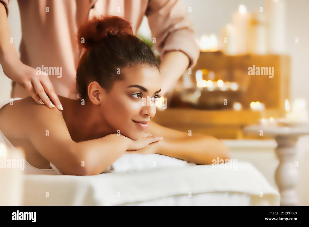 Belle fille africaine souriante profitant d'un massage au spa. Banque D'Images