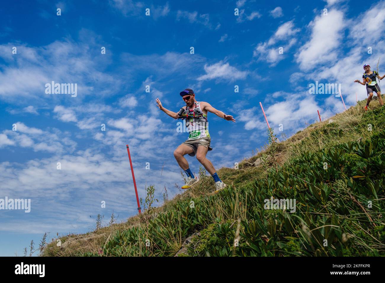 Rosa Khutor, Russie - 10 septembre 2022: Athlète masculin descendant une pente abrupte dans le sentier sauvage de Rosa Banque D'Images Rosa Khutor, Russie - 10 septembre 2022: Athlète masculin descendant une pente abrupte dans le sentier sauvage de Rosa Banque D'Images