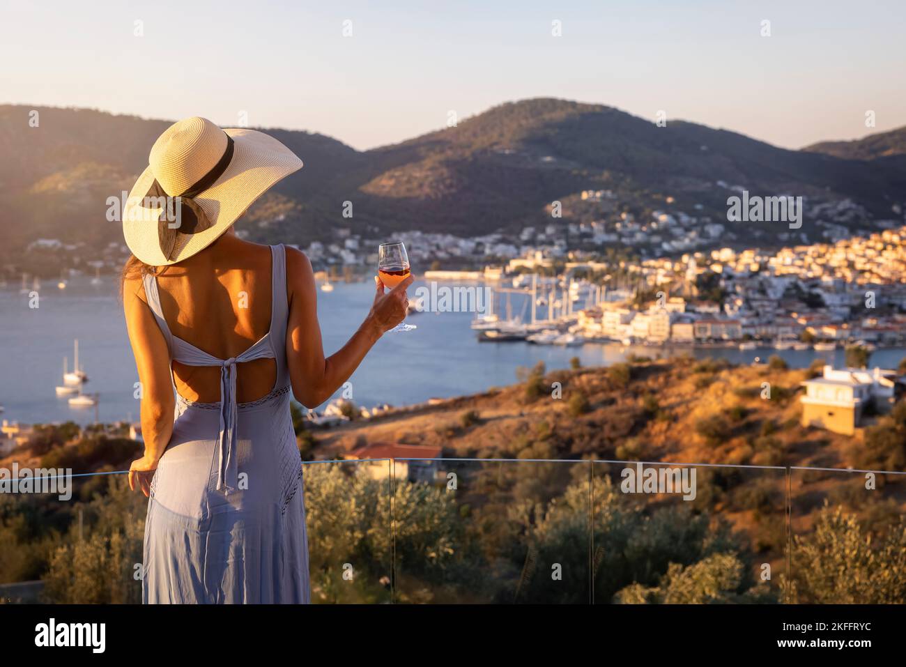 Une belle femme avec un chapeau bénéficie du coucher de soleil sur la mer méditerranée Banque D'Images