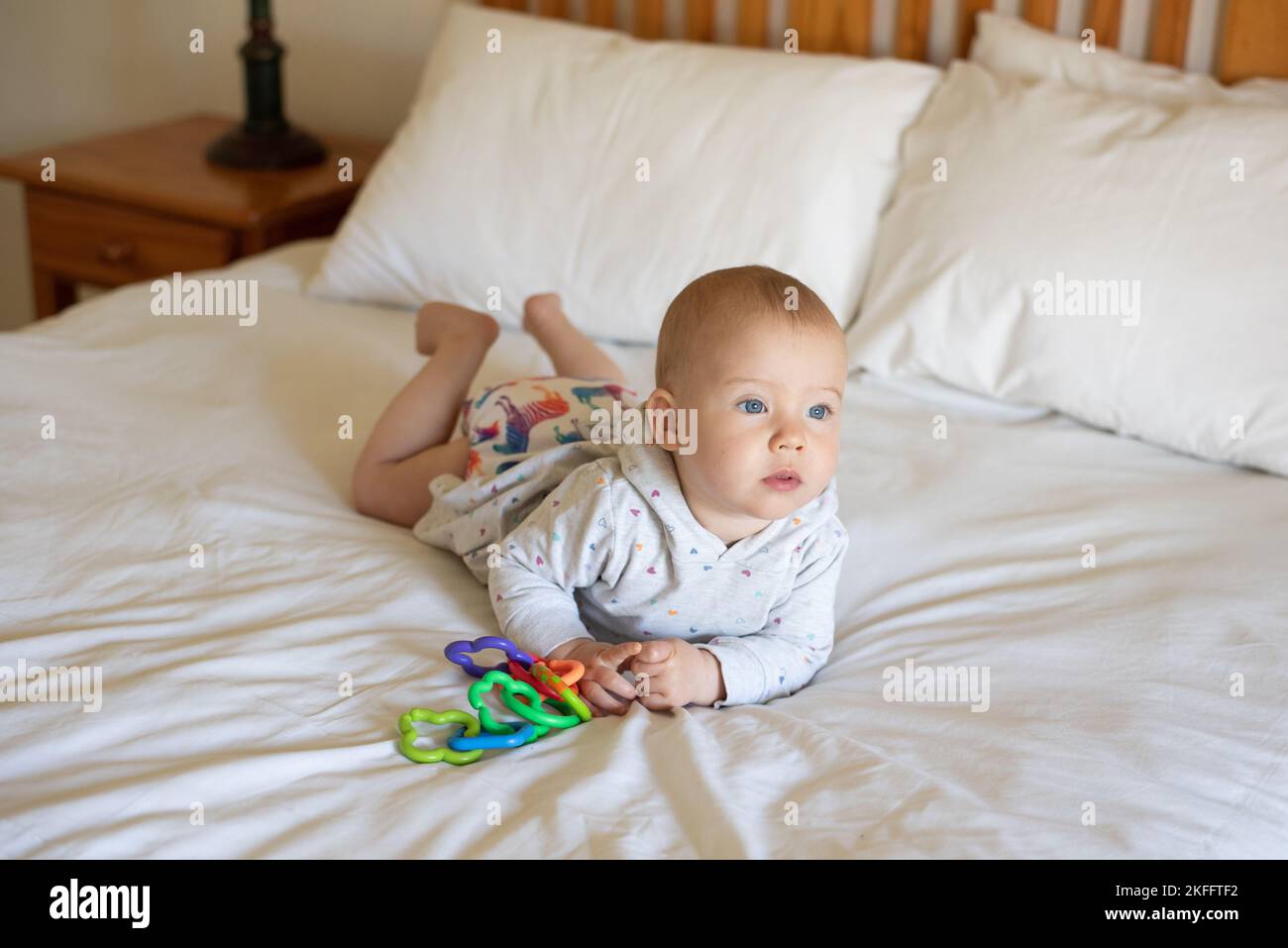 Une petite fille couchée sur son ventre faisant le temps de ventre pour renforcer son dos. Elle porte une couche de tissu moderne et réutilisable Banque D'Images