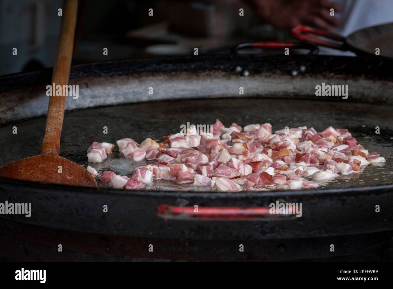 Des morceaux de bacon sont rôtis et cuits sur un poêle en plein air lors d'un festival gastronomique hongrois Banque D'Images