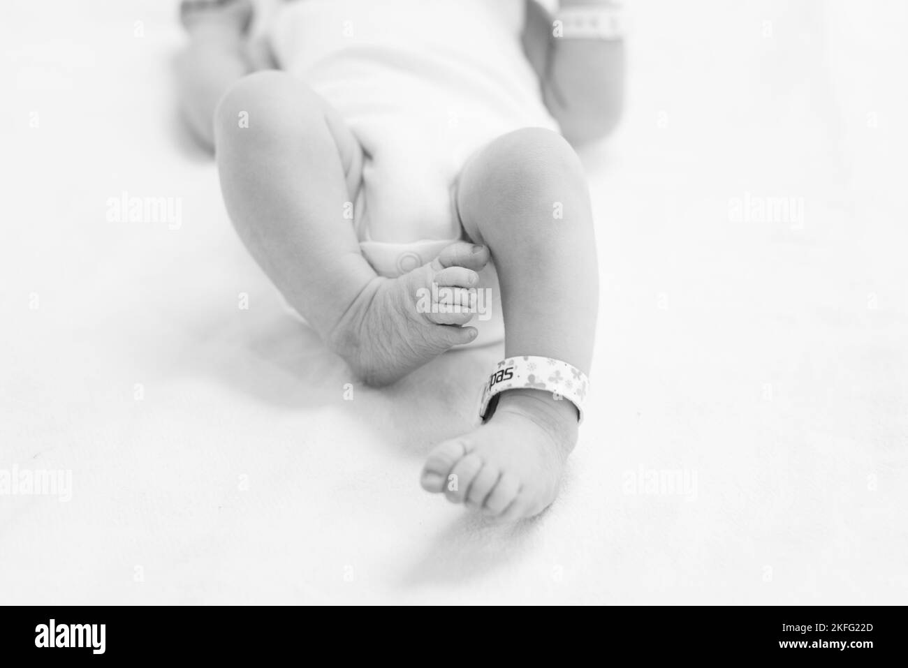 Un nouveau-né à l'hôpital étant nettoyé par un médecin après la naissance. Les pieds du bébé sont visibles sur l'image Banque D'Images