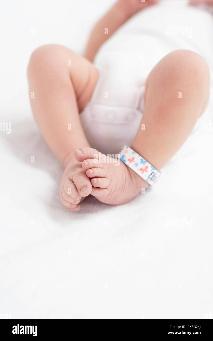 Un nouveau-né à l'hôpital étant nettoyé par un médecin après la naissance. Les pieds du bébé sont visibles sur l'image Banque D'Images