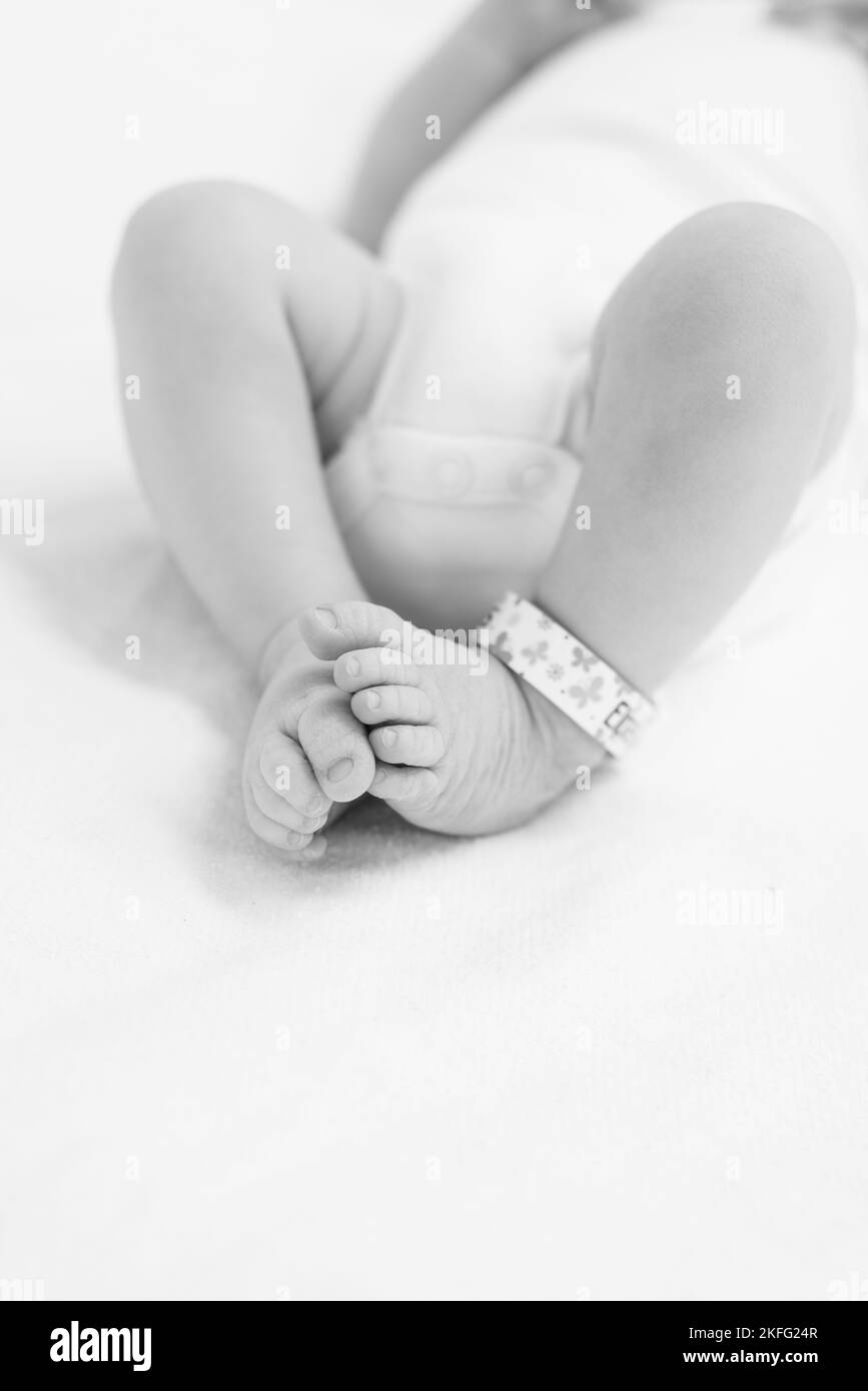 Un nouveau-né à l'hôpital étant nettoyé par un médecin après la naissance. Les pieds du bébé sont visibles sur l'image Banque D'Images