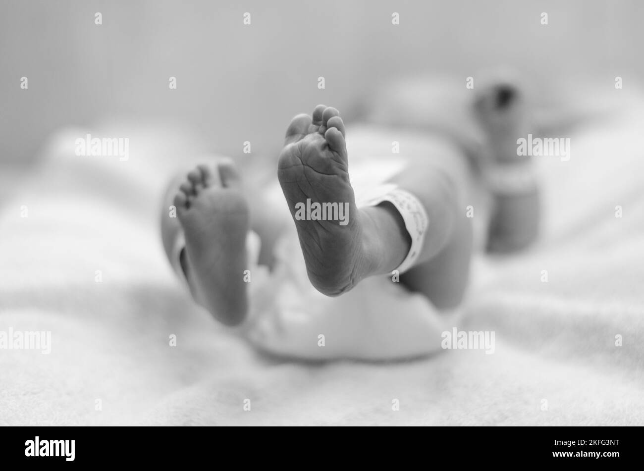 Un nouveau-né à l'hôpital étant nettoyé par un médecin après la naissance. Les pieds du bébé sont visibles sur l'image Banque D'Images