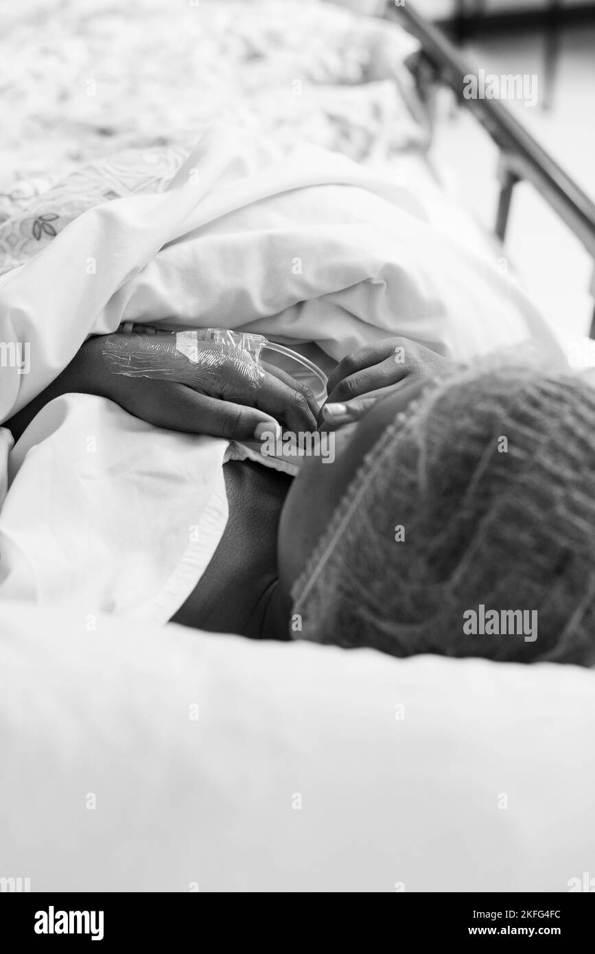 Une patiente dans le lit d'hôpital avec une ligne IV dans la main, attendant la chirurgie Banque D'Images