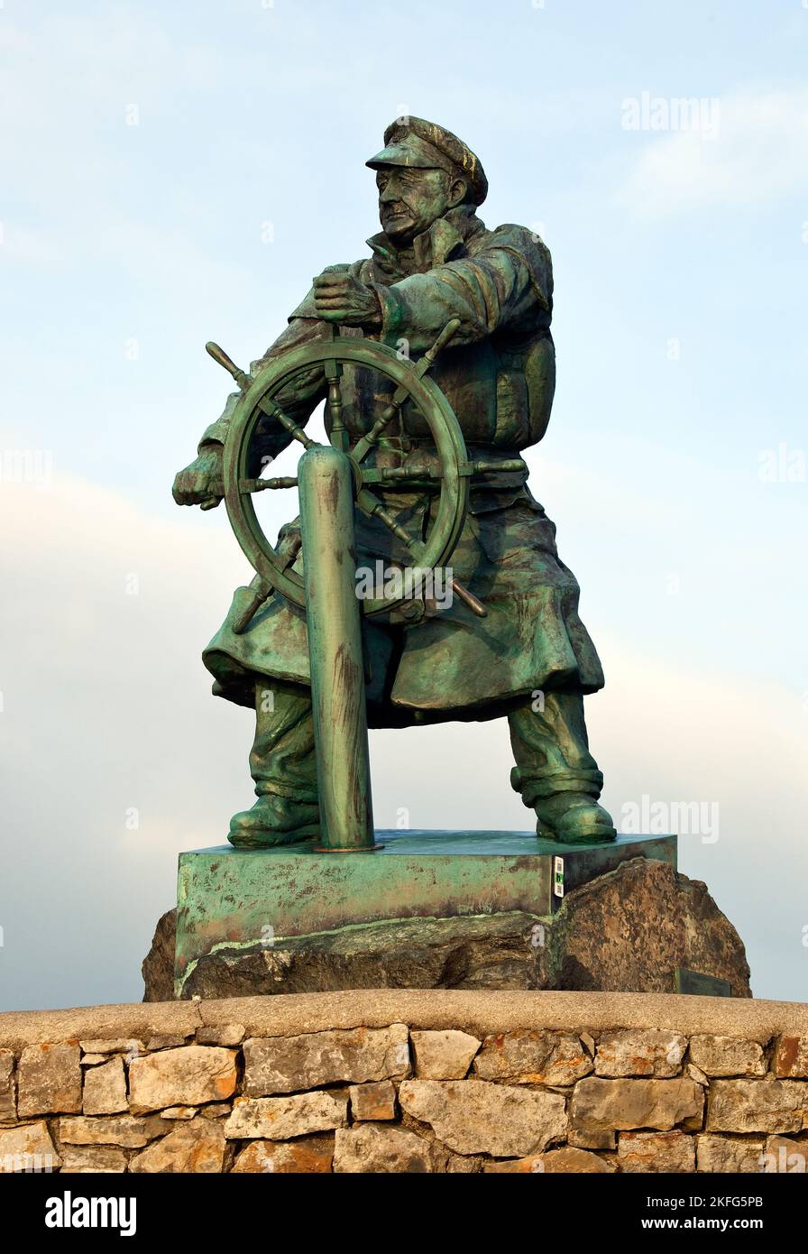 Royal National Lifeboat institution. Sculpture en bronze du héros de Lifeboat Coxswain Richard (DIC) Evans, vue depuis le sentier côtier de Moelfre sur l'île de Banque D'Images