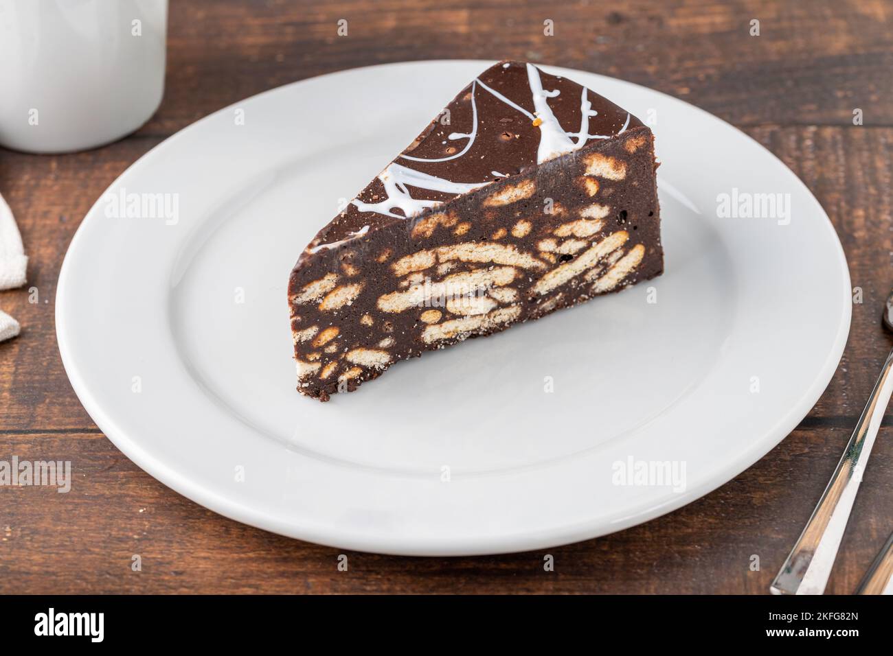 Gâteau en mosaïque de chocolat sur une assiette en porcelaine blanche avec du café filtre sur le côté Banque D'Images