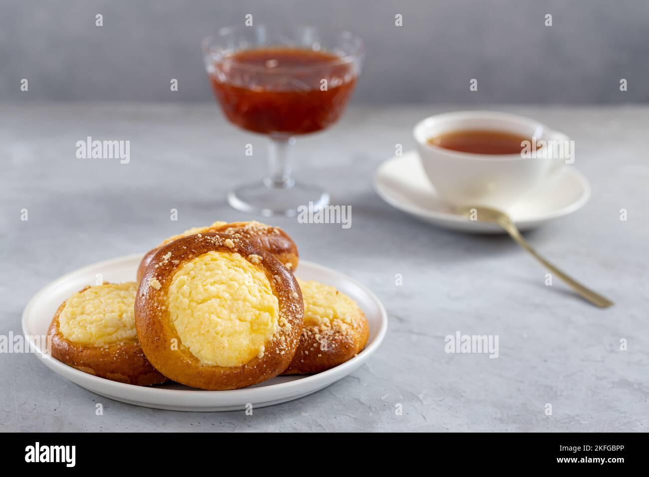cheesecake avec streusel sur fond de béton, thé avec tartes et confiture Banque D'Images