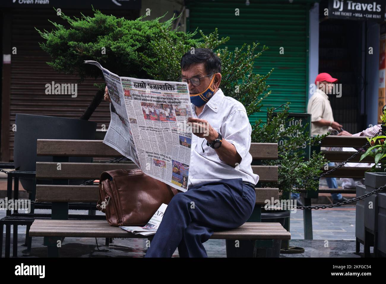 Gangtok, INDE, 21 juin 2022, homme d'âge moyen lisant des journaux sur le côté de la route. Banque D'Images