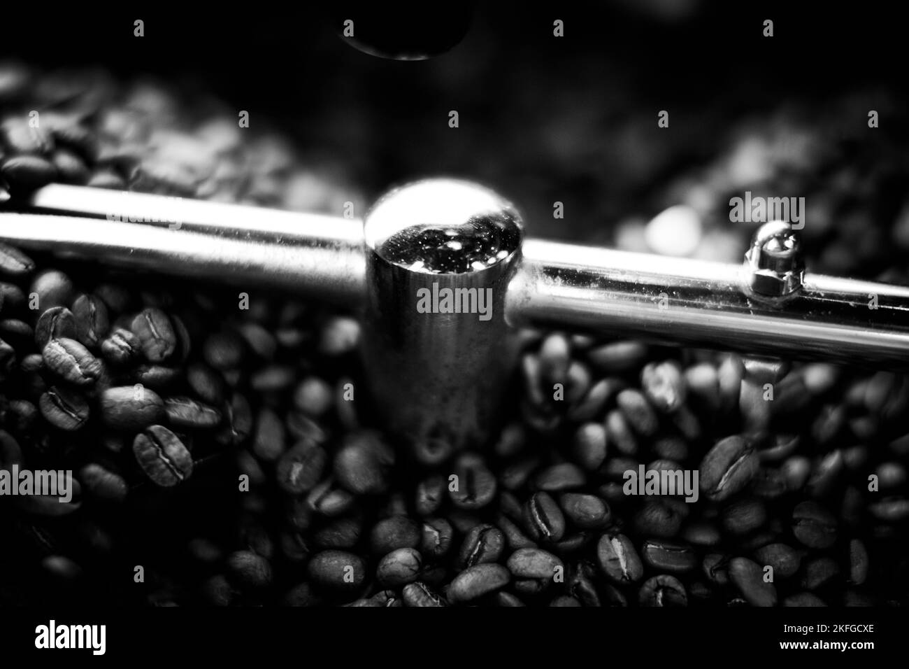 Grains de café dans une machine à café, dans des couleurs sombres. Banque D'Images