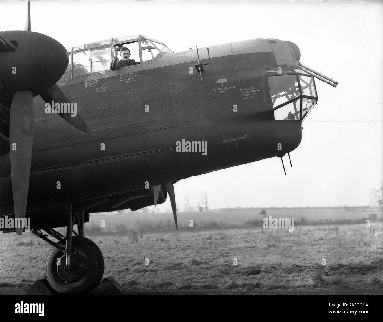 1948, historique, un pilote de la RAF qui agite depuis le poste de pilotage d'un bombardier Avro Lancaster s'assit sur un terrain à la RAF Ternhill, Longford Camp, Market Drayton, Angleterre, Royaume-Uni. Conçu par Roy Chadwick, le Lancaster était un bombardier lourd de WW2 fabriqué par Avro (A.V. ROE and Company), un fabricant britannique fondé en 1910 à Manchester, dans le Lancashire, en Angleterre, au Royaume-Uni. Le prototype du Lancaster a effectué son vol inaugural en janvier 1941. L'avion avait un équipage de sept hommes, dont l'âge moyen n'était que de 22 ans. Banque D'Images